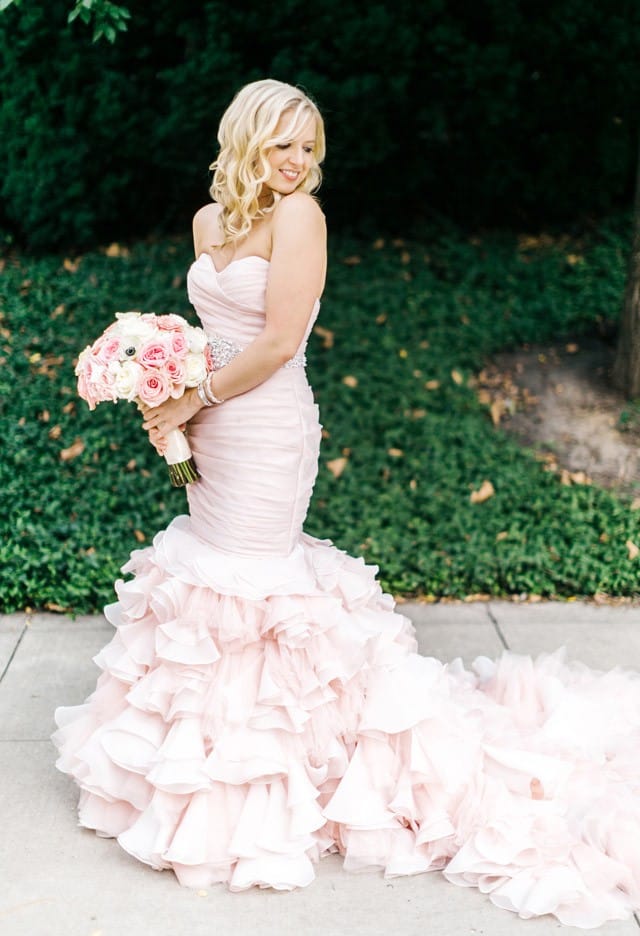 Maggie Bride Laurie wearing a blush fit-and-flare wedding dress.