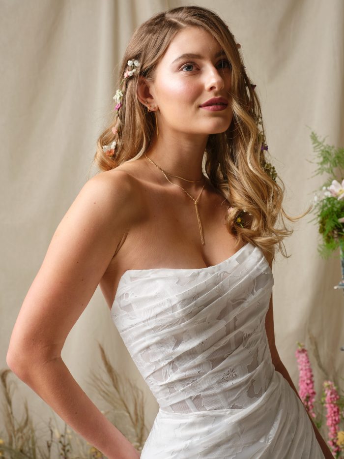 Kendall by Rebecca Ingram strapless wedding dress featuring ruched organza bodice and soft cat eye neckline detail